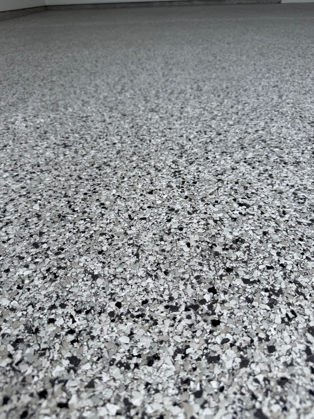 Close-up of textured grey epoxy floor with speckled surface detail.